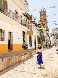 a woman is walking down the street in front of some buildings