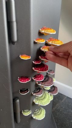 a hand is reaching into a refrigerator with magnets on it