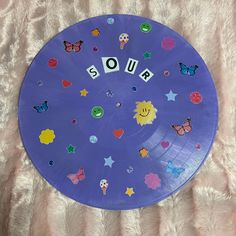 a purple plate with the word quiz spelled out in letters on it, surrounded by butterflies and stars