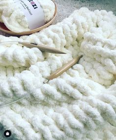 a pile of white crochet next to a pair of scissors