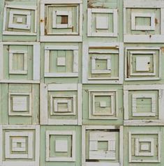 many square and rectangle frames are arranged in an old, green - painted wall