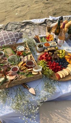 two wooden trays filled with different types of food on a picnic table next to each other