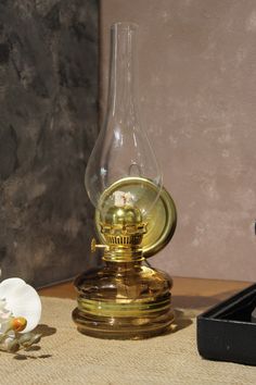 a glass vase sitting on top of a table next to a candle holder and flower