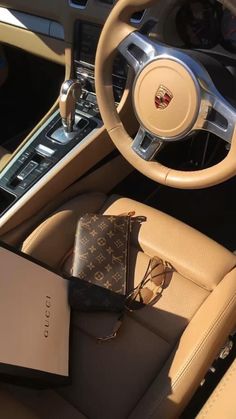 the interior of a luxury car with an open book and purse on the dash board