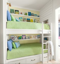 bunk beds with green covers and pillows in a child's playroom or bedroom