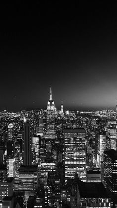 black and white photo of the city at night with skyscrapers in the foreground