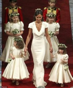 the bride and her flower girls walk down the aisle at their wedding ceremony in london