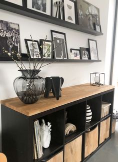 a shelf with some pictures and vases on it