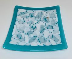 a blue and white plate with pieces of glass on it