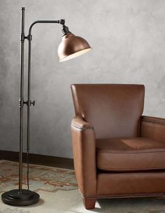 a brown leather chair sitting next to a lamp