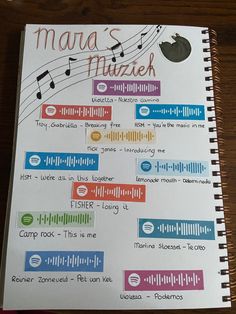 an open spiral notebook with music notes on the pages and words written in different languages