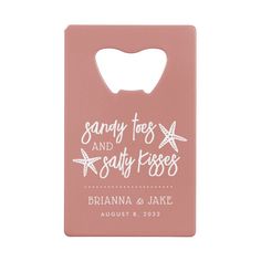 a pink bottle opener with the words sandy toes and salty kisses on it's front