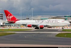 a virgin atlantic airplane on the runway at an airport