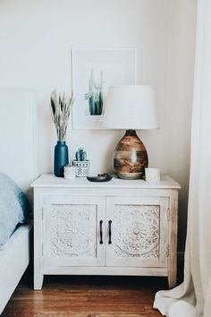 a bedroom with a bed, nightstand and pictures on the wall