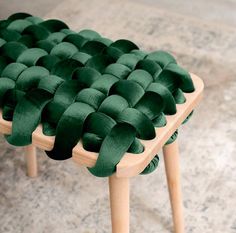 a wooden bench with green fabric on it