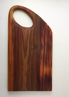 a wooden cutting board on a white wall