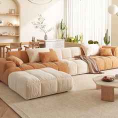 a living room filled with lots of furniture and plants on the wall behind the couch