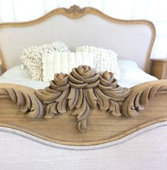 an ornate wooden bed frame with white pillows