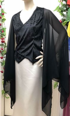 a mannequin wearing a black top with sheer sleeves