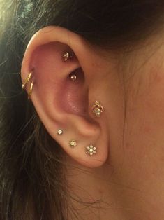 a close up of a person's ear with three different piercings on it