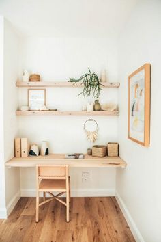 a wooden desk sitting in the corner of a room next to a wall with shelves on it