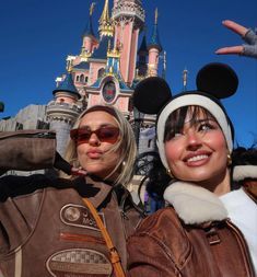 two women pose for a photo in front of the castle at disneyland california disney world