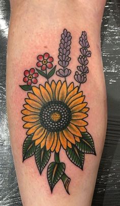 a sunflower and lavenders tattoo on the right leg, done by an artist