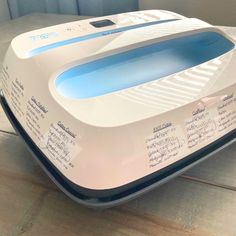 a white and blue toaster sitting on top of a wooden table