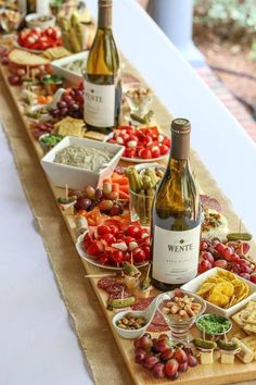 a table filled with lots of different types of food and wine bottles on top of it