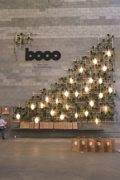 a person sitting on a bench in front of a wall covered with lights and boxes