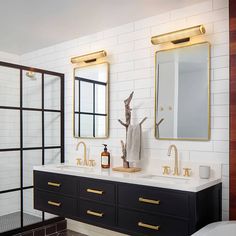 a bathroom with two sinks and mirrors on the wall