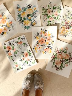 there are many cards with flowers on them and one has a pair of shoes next to it