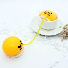 two eggs with faces drawn on them are being tied to a string by a saucer