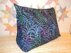 a decorative pillow on a bed in front of a wallpapered background with stars