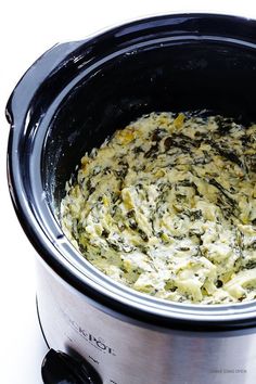 a crock pot filled with spinach and cheese