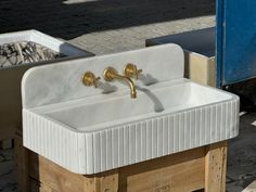 a white sink sitting on top of a wooden pallet