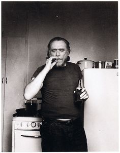 a man standing in front of an oven holding a bottle