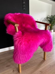 a pink chair sitting on top of a hard wood floor