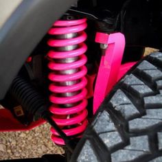 the front end of a motorcycle with pink springs