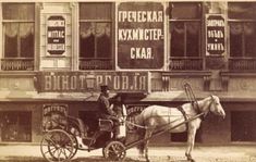 an old black and white photo of a man riding in a horse - drawn carriage