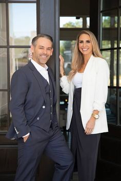 a man and woman standing next to each other in front of a door with glass windows