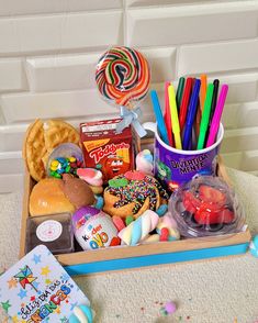 a wooden box filled with lots of candy and candies on top of a table