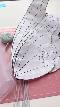 a paper butterfly sitting on top of a table next to scissors and other crafting supplies