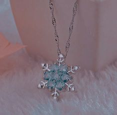 a snowflake necklace is shown on a fur surface