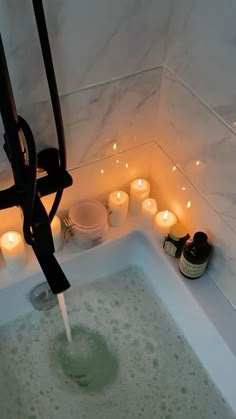 a bathtub filled with lots of candles and soap