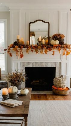 a living room with a fire place filled with candles and pumpkins on the mantle