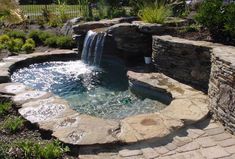 a small waterfall in the middle of a garden