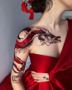 a woman in a red dress with tattoos on her arm