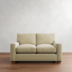 a couch sitting on top of a hard wood floor next to a white wall in an empty room