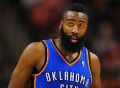 a basketball player with a beard is looking at the camera while wearing a blue uniform